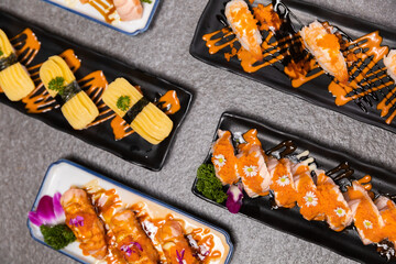 Sashimi sushi set with soy on black background.Assorted sushi set served on dark stone slate background. Top view