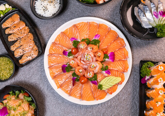 Sashimi sushi set with soy on black background.Assorted sushi set served on dark stone slate background. Top view