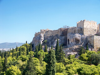 part of a ruined castle on a mountain surrounded by a forest in summer