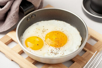 Fried eggs in a pan  and coffee on the table. Healthy breakfast