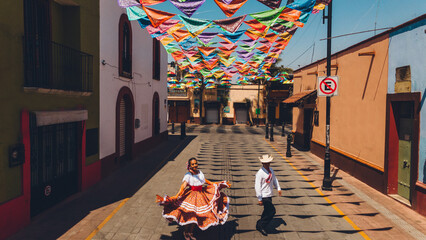 Aerial photo of dancers of typical Mexican dances from the downtown region, doing their performance in the street adorned with bandanas.