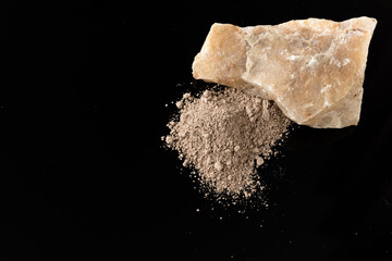 Mineral sorbent in the form of a powder on a black background, the concept of a healthy lifestyle, close-up, space for text