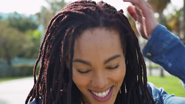 Young beautiful woman with dreadlocks hairstyle smiling at camera.