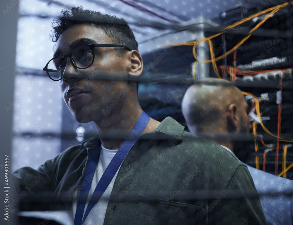 Poster Sorting out the server. Cropped shot of two male IT support agents working together in a dark network server room.