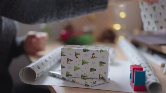 Close up of woman assembling wrapped presents for gifting them on Christmas.