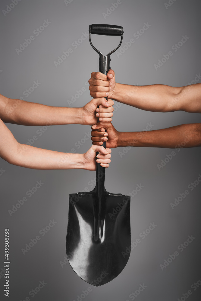 Aufkleber building our future together. studio shot of unidentifiable hands holding on to a shovel against a g