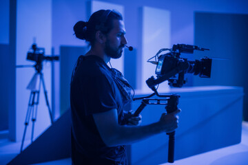 Director of photography with a camera in his hands on the set. Professional videographer at work on...