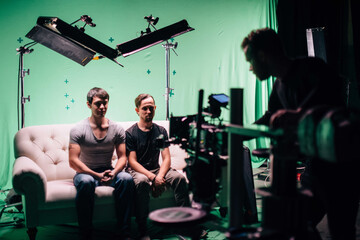 Professional male actors work in the frame on the set. Shooting with actors on a big green chroma...