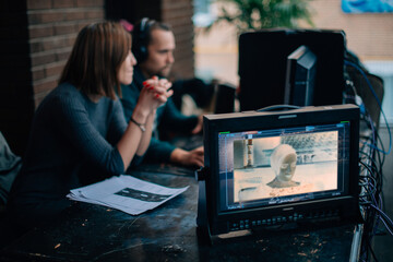 Editing director behind monitors on the set. A video editor edits video online while filming for a...