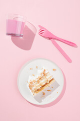 a piece of cake with nuts on a pink plate and a pink background. Pink cutlery and decorations. Pink mood.