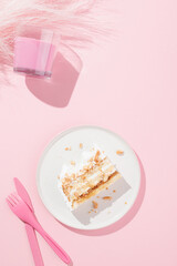 a piece of cake with nuts on a pink plate and a pink background. Pink cutlery and decorations. Pink mood.