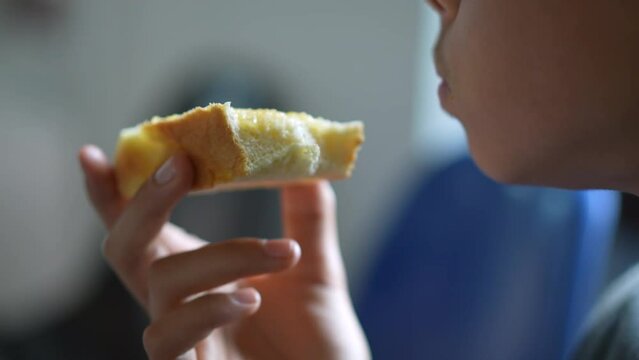 Child eating bread brioche in the morning breakfast