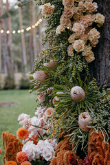 Outdoor wedding ceremony. Composition of chrysanthemums, pampas grass, protea and roses