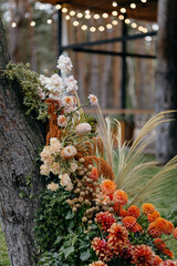 Outdoor wedding ceremony. Composition of chrysanthemums, pampas grass, protea and roses