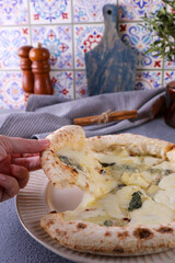 Neapolitan pizza 4 cheeses on a plate in the kitchen