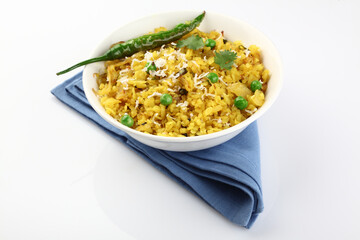 Kande Pohay OR Aloo Pohe is a popular Indian breakfast recipe made using Flattened rice, usually served with hot tea. Served in a bowl over moody background. Selective focus