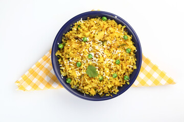 Kande Pohay OR Aloo Pohe is a popular Indian breakfast recipe made using Flattened rice, usually served with hot tea. Served in a bowl over moody background. Selective focus
