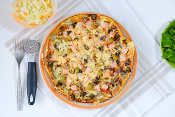 Healthy vegan lunch - homemade pizza with fresh vegetable salad and dill and parsley. Top view. Italian traditional meal on a light natural linen napkin. Cooking food at home. Menu, cafe, restaurant.