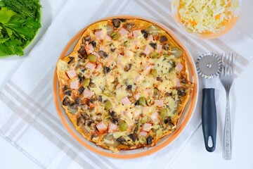 Healthy vegan lunch - homemade pizza with fresh vegetable salad and dill and parsley. Top view. Italian traditional meal on a light natural linen napkin. Cooking food at home. Menu, cafe, restaurant.