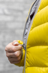 a woman zips up the zipper on her colored jacket with her hand © Oleg Opryshko