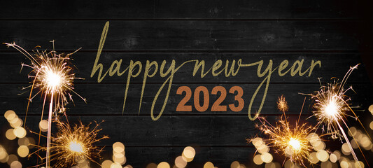 Bokeh golden flares and sparkler isolated on rustic black wooden texture - Holiday New Year's Eve...