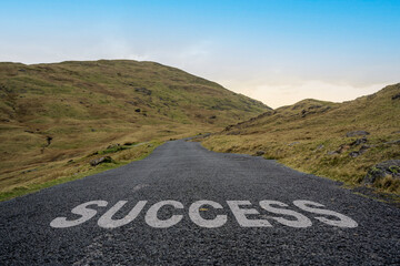 Success written on a mountain pass road in the Lake District.