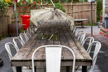 Closeup of long meeting table and white stools at the manor outdoor