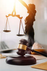 law books and scales of justice on desk in library of law firm. jurisprudence legal education...