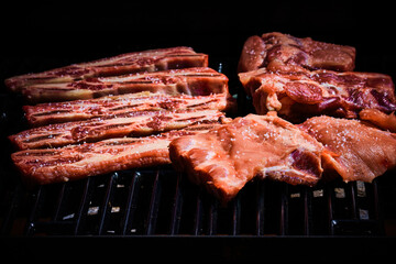 Beef rib and pork rib freshly put on the barbecue to start grilling