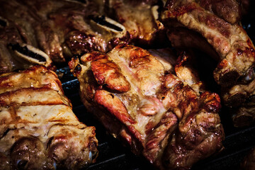 juicy beef rib and pork rib slowly being made on the grill on the fire at a gas barbecue