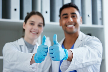 Our research will make a big difference. Closeup shot of two scientists showing thumbs up in a lab.