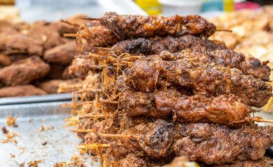 Grilled chicken sticks on a street food market close up with selective focus