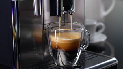 Coffee machine filling a cup with expresso. 