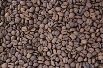 Fullframe shot of roasted coffee beans frome close up. Brown aromatic seeds on background.