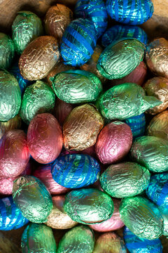 Pastel colored easter-eggs wrapped in foil, pink, gray, gold, blue
