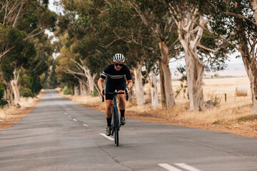 Professional cyclist practicing on a long empty road