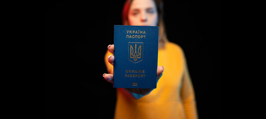 Ukraine national passport. Beautiful ukrainian girl with government passport in her hands on black background.