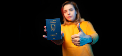 Ukraine national passport. Beautiful ukrainian girl with government passport in her hands on black background.