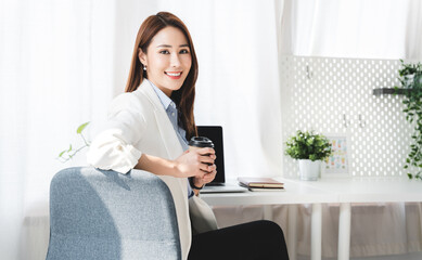 happy business woman working and holding a coffee cup at the office