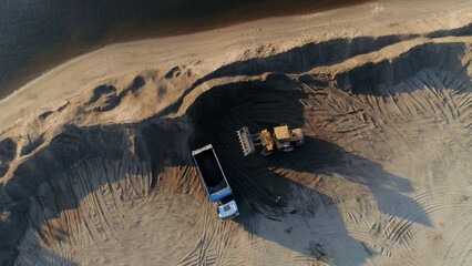 Sand mining industry, sand mine at the quarry. Scene. Aerial top view of a bulldozer machine...