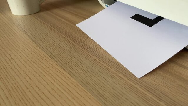 Printing &ldquo;LIE&rdquo; text written message on paper sheet document. Close up A4 page being printed from multifunction scanner printer on wooden desk in office. Hand take paper from printer