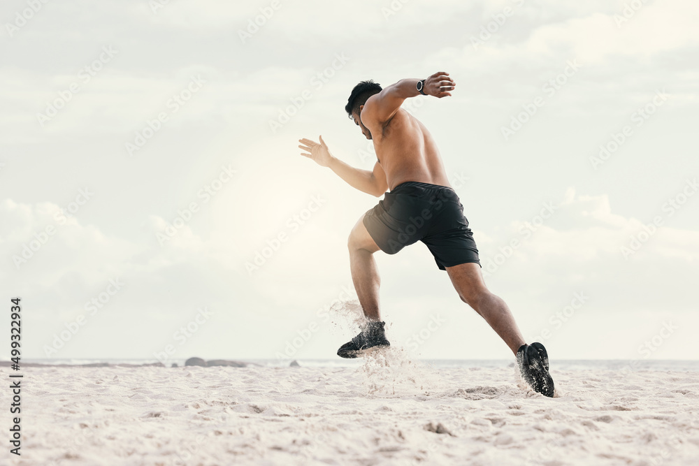 Canvas Prints Fast or slow, just go. Shot of a young man out for a run on the beach.