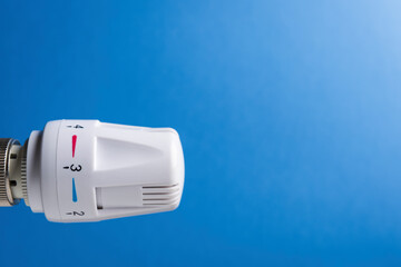 Heating thermostat isolated on blue wall with copy space. Close up