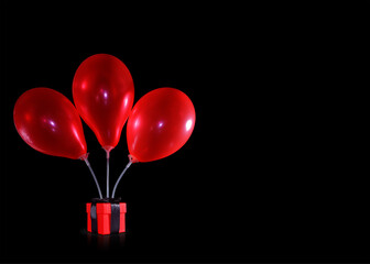 three red balloons above the gift box