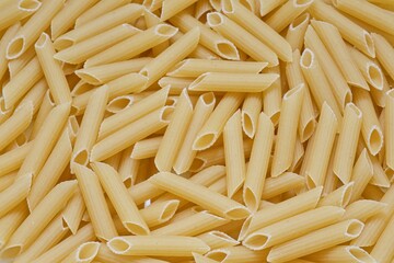 Lot of pasta penne. Dry macaroni texture. Food background.