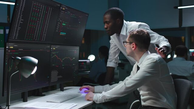 Team of it programmers working on desktop computers in data center control room. 