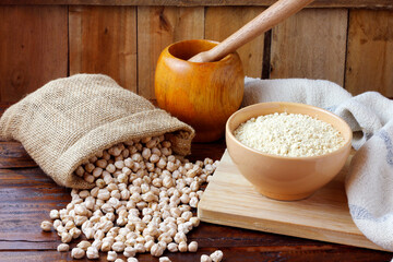 Organic chickpea flour in bowl over rustic wooden table