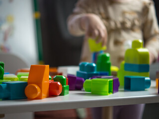 children's constructor close-up against the background of a playing child