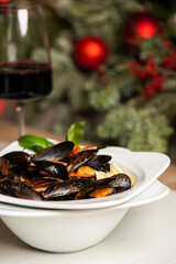 Freshly cooked Seafood Shellfish mussels with cream, wine, cheese sauce and lemon in a white bowl, close-up, studio shot. A classic dish in Belgium, France and Netherlands. Restaurant food.