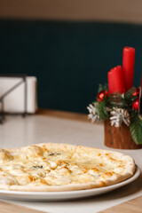 Four cheese pizza quattro formaggi with glass of wine on background with new year decorations.